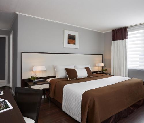 马尼拉Astoria Plaza的酒店客房设有一张大床和一张书桌。