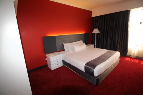 哥打巴鲁大宏酒店的酒店客房,设有床铺和红色的墙壁