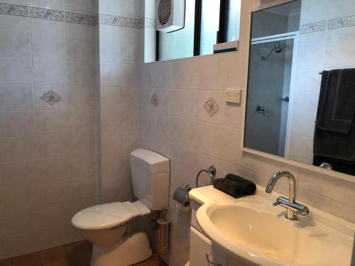 古尔本古尔本汽车旅馆的一间带卫生间、水槽和镜子的浴室