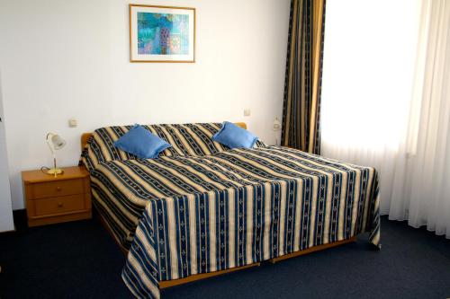 埃森博白克城堡酒店的一间卧室配有一张带蓝色枕头的床。