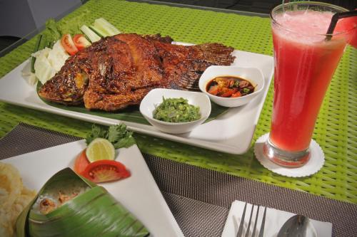芝拉扎Whiz Prime Hotel Sudirman Cilacap的桌上的肉和饮料