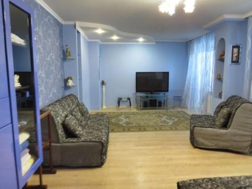 苏梅Apartments on Kharkovskaya Street的客厅配有2把椅子和平面电视