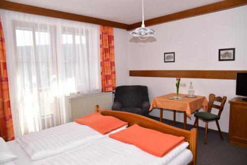MiesenbachFlorianihof的一间卧室配有两张床、一张桌子和一把椅子