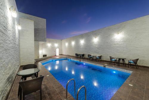 利雅德Braira Al Wezarat的一座带椅子和桌子的酒店游泳池