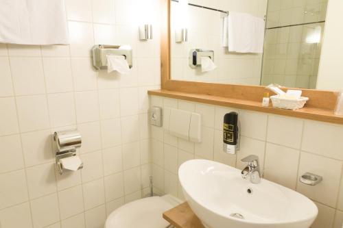 彭茨贝格柏格思特城市酒店的一间带水槽、卫生间和镜子的浴室