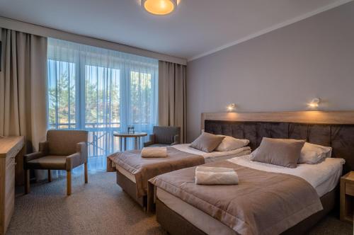 雅罗斯瓦维茨Hotel *** NAT Jarosławiec的酒店客房设有两张床和一个阳台。