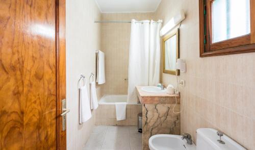 卡门港洛斯费斯克斯蓝海酒店的浴室配有盥洗盆、卫生间和浴缸。