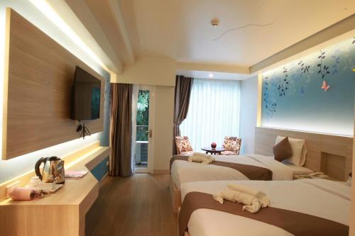 芭堤雅市中心Levana Pattaya Hotel - SHA Extra Plus的酒店客房设有两张床和电视。