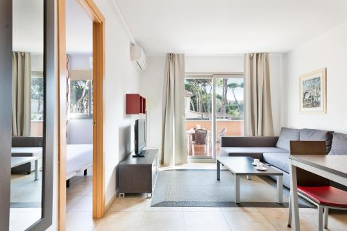 卡斯特尔德费尔斯巴登公寓式酒店的客厅配有沙发和桌子