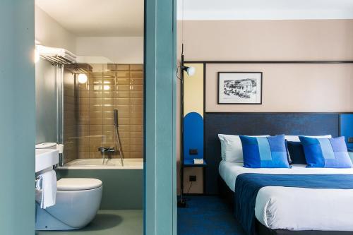尼斯希佳乐酒店的一间卧室配有一张床,浴室设有浴缸