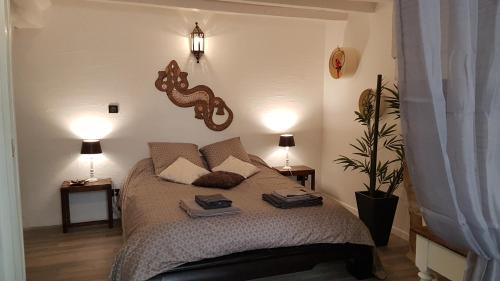 萨尔特河畔博蒙La belmontaise的一间卧室配有一张带两盏灯的床。