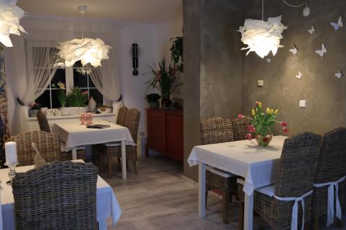 布拉格家庭旅馆的餐厅配有白色的桌椅和灯光