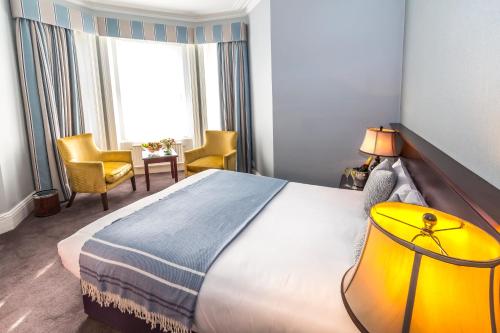 伯恩茅斯康诺特旅馆的一间设有大床和窗户的酒店客房