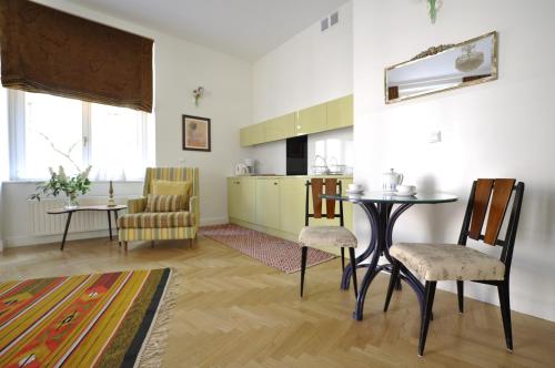 克拉科夫水晶套房老城区酒店的厨房以及带桌椅的起居室。