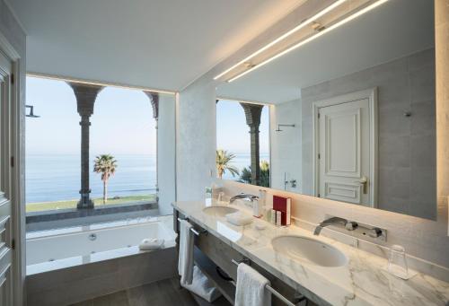 锡切斯Hotel Casa Vilella 4* Sup的一间带两个盥洗盆和大镜子的浴室