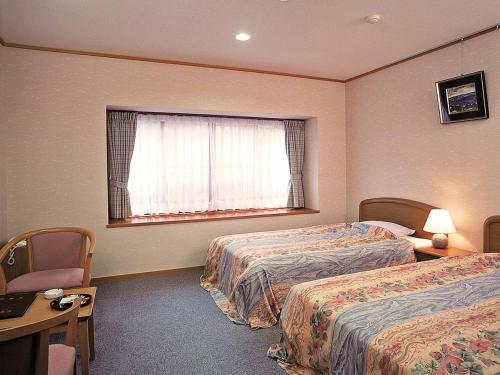 中之条糸園岛酒店的酒店客房设有两张床和窗户。