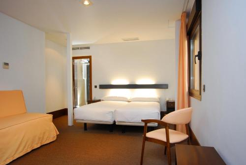 托莱多则卡多瓦广场多莫斯酒店的配有一张床和一把椅子的酒店客房