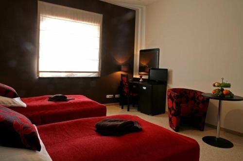 彼得库夫特雷布纳尔斯基阿尔塔米拉酒店的一间卧室设有两张床、一把椅子和一个窗户。