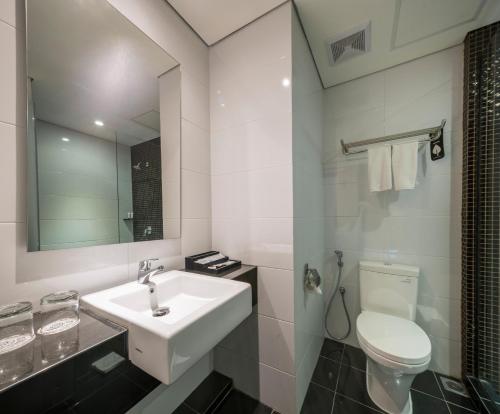泗水Luminor Hotel Jemursari By WH的白色的浴室设有水槽和卫生间。