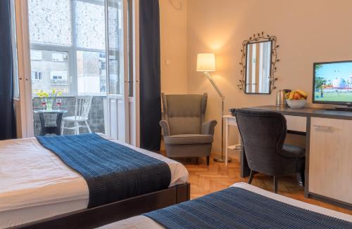 贝尔格莱德精选客房旅馆的酒店客房配有一张床和一张书桌及一台电视