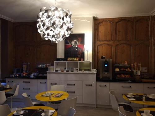 拉罗谢尔大西洋酒店的厨房配有桌椅和吊灯。