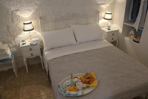 滨海波利尼亚诺La Casetta 19的一间卧室配有一张床,上面放着一个食物托盘