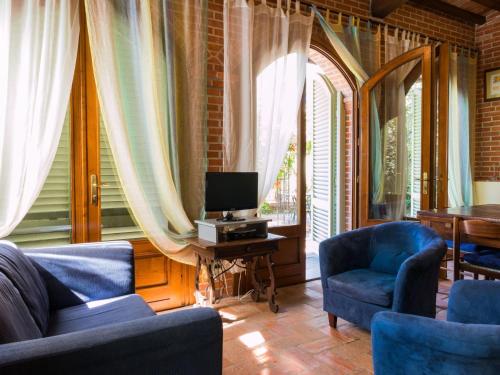 尼阿博勒皮耶韦Belvilla by OYO Nice Farmhouse with Sauna Jacuzzi的客厅配有2把蓝色椅子和电视