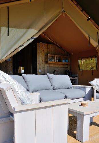 东福尔讷Safaritent的一张沙发,在帐篷里,配有一张桌子