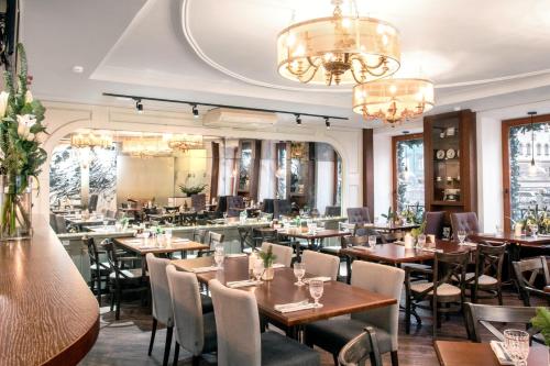 圣彼得堡普斯卡客栈酒店的餐厅设有桌椅和吊灯。