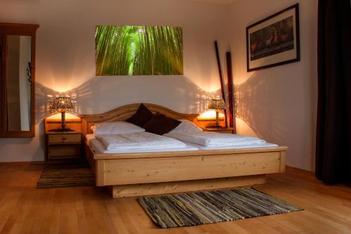 梅滕Mettner Hof的一间卧室配有一张木床,两台台灯放在两张桌子上