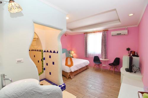 鹅銮鼻磐石旅店的卧室设有粉红色的墙壁和一张床