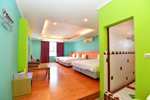 鹅銮鼻磐石旅店的一间卧室设有两张床,拥有绿色的墙壁