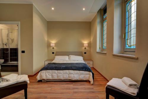 都灵马特奥迪25号酒店的一间卧室设有一张大床和两个窗户。