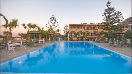 卡马利圣埃伦娜酒店的一座蓝色的大型游泳池,其建筑背景为: