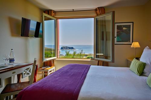 班戈海洋美丽岛大大酒店的一间卧室配有一张床、一张书桌和一个大窗户