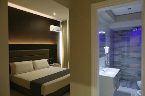 那不勒斯威斯碧连酒店的一间卧室配有一张床,浴室设有水槽