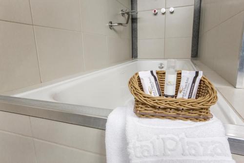 戈亚尼亚水景广场酒店的浴室设有浴缸旁的毛巾篮