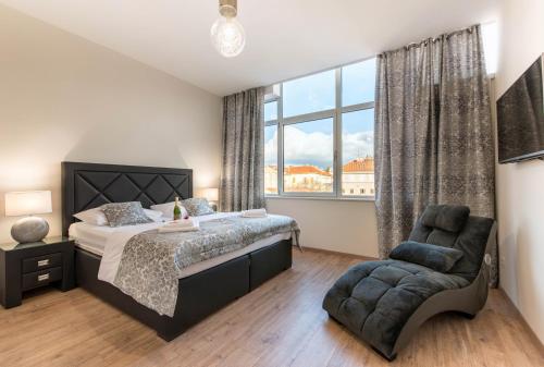 斯普利特斯巴拉多普里马生活旅馆的卧室配有床、椅子和窗户。