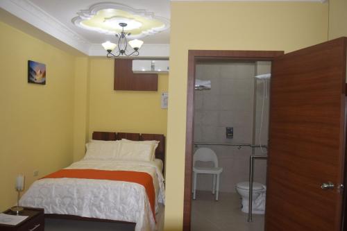埃斯梅拉达斯Olan´s Hotel Group的一间卧室配有一张床,浴室设有淋浴。