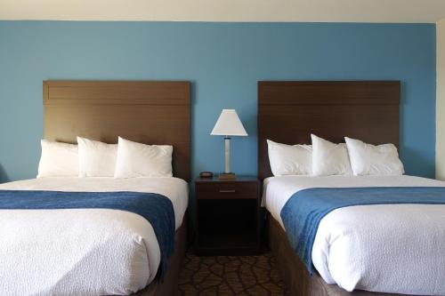 汤森港港畔酒店的两张位于酒店客房的床,拥有蓝色的墙壁