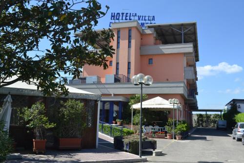 福贾La Villa dei Gourmets - Struttura Sanificata的前面有一把伞的粉红色建筑