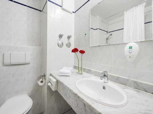 埃尔丁Andante Hotel Erding的白色的浴室设有水槽和镜子