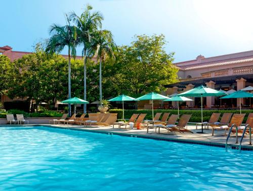 帕萨迪纳帕萨迪纳亨廷顿朗廷酒店的一个带椅子和遮阳伞的游泳池