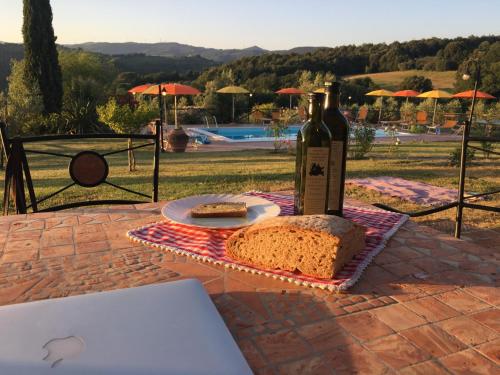 蒙泰卡蒂尼瓦尔迪切奇纳Farmhouse Gello by ToscanaTour的桌子上放着一瓶葡萄酒和一面包