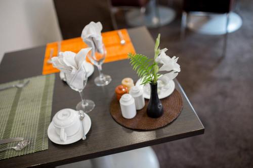 塔那那利佛塔娜酒店的一张桌子,上面放着两杯酒,花瓶上放着鲜花