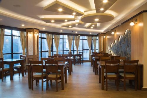 大吉岭Jai Hotels的用餐室设有桌椅和窗户。
