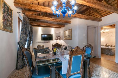 威尼斯San Marco Luxury apartments Muneghe的一间带桌椅和吊灯的用餐室