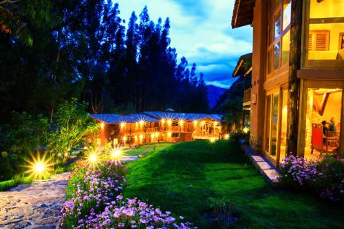 乌鲁班巴神圣梦想小屋酒店的一座花园,晚上在大楼里灯光照亮