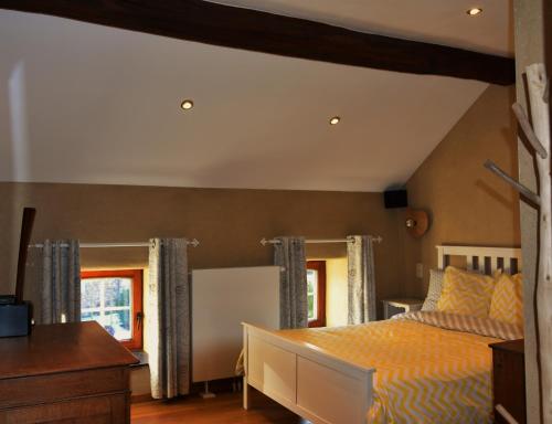 EngisLes houx de Mathieu的卧室配有一张床、一张书桌和窗户。