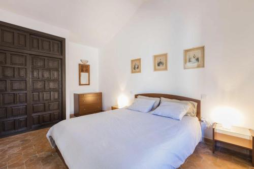 卡门港Vivienda Vacacional Casetta Volante的一间卧室配有一张带两盏灯的大型白色床。